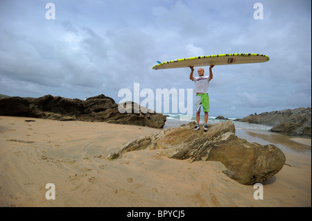 Ein Surfer, Ben Howey, hält ein Longboard Surfbrett am Strand von Fistral, Newquay, Großbritanniens Hauptstadt, in Cornwall Stockfoto