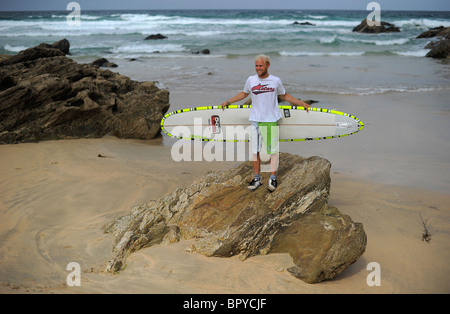 Ein Surfer, Ben Howey, hält ein Longboard Surfbrett am Strand von Fistral, Newquay, Großbritanniens Hauptstadt, in Cornwall Stockfoto