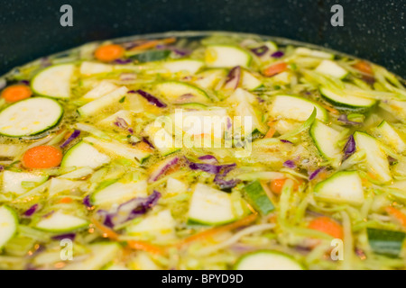 Gemüse in Hühnerbrühe kochen. Einer der Schritte bei der Herstellung hausgemachte Hühnersuppe. Stockfoto