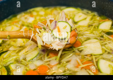 Kochlöffel in einen Topf Suppe. Letzte Schritt bei der Herstellung hausgemachte Hühnersuppe. Stockfoto