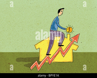 Ein Mann hält Geld und Klettern ein Diagramm vor einem Haus Stockfoto