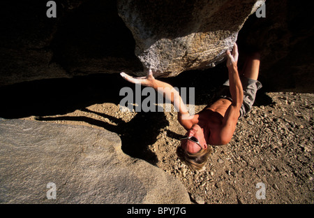 Eine Draufsicht eines Mannes auf einen überhängenden Felsen in der Wüste Klettern in den Bergen eingebettet. Stockfoto