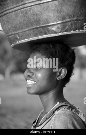 Frau mit einem Eimer auf dem Kopf, Cape Maclear, Malawi Stockfoto