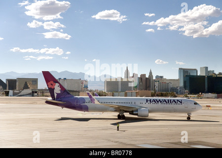 Ein Hawaiian Airlines Flugzeug auf dem Rollfeld am Flughafen Las Vegas mit dem Streifen im Hintergrund, Las Vegas Nevada, USA Stockfoto