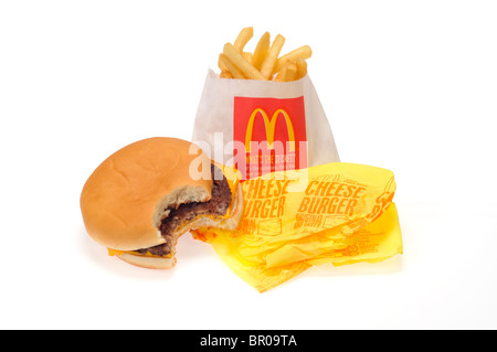 McDonald's-Cheeseburger mit einem Biss auf seine Wrapper und Pommes Frites auf weißem Hintergrund Ausschnitt genommen. Stockfoto