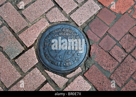 Wasser m historischen Kanaldeckel in der Französisch Quarter von New Orleans, Louisiana, USA Stockfoto