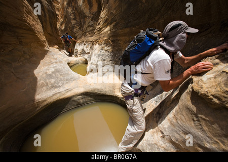 Man durchquert um Schlagloch beim Abstieg Wüste Canyon, San Rafael Swell, Utah Stockfoto