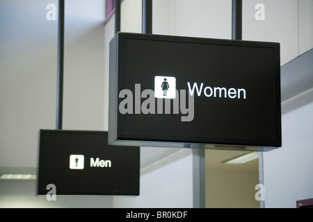 Schilder für Männer und Frauen, Toiletten am Flughafen von Las Vegas; Nevada USA. Konzept Frauen vor Männern; Frauen vor Männern; Männer hinter Frauen. Stockfoto