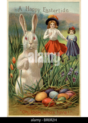 Eine Postkarte Ostern von zwei Mädchen läuft auf ein Kaninchen und ein Nest von gefärbten Eiern Stockfoto