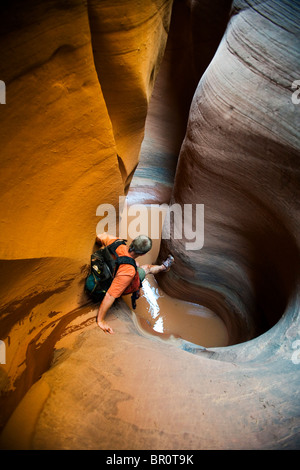 Ein Mann, der Abstieg ins Wasser in geformten Slotcanyon, Utah. Stockfoto