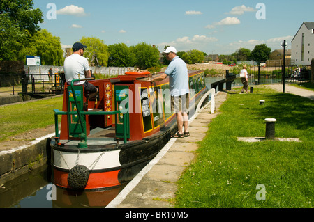 Ein Kanal Narrowboat durchläuft eine Sperre auf dem Ashton Kanal in Droylsden, Tameside, Manchester, England, UK Stockfoto