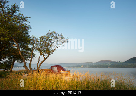 Eine Szene in der Morgendämmerung mit einem Motorboot Verlegung am Ufer Ullswater Seenplatte UK Stockfoto