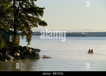 Eine Kanu lagen die Gewässer im Morgennebel von Sebago See in Maine. Stockfoto