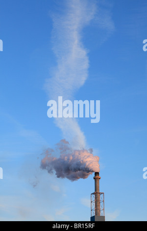 Wolkenbildung und Rauchschwaden aus einem Schornstein. Stockfoto