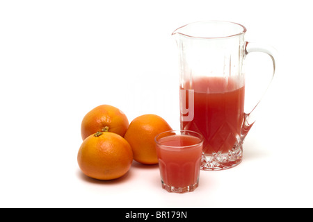 Grapefruits mit einem Krug und Glas frisch gepresster Grapefruitsaft Stockfoto