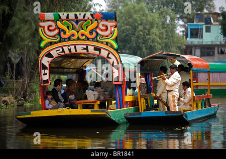 Mariachi Musiker spielen mexikanische Lieder für Touristen in einem Boot durch die Wasserkanäle von Xochimilco auf der Südseite von Mexiko C Stockfoto