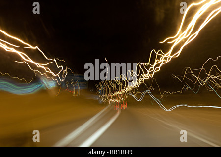 unscharfe Lichter auf einer Autobahn, entnommen aus einem fahrenden Auto Stockfoto