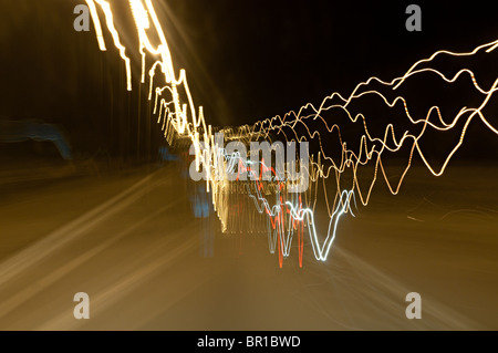 unscharfe Lichter auf einer Autobahn, entnommen aus einem fahrenden Auto Stockfoto