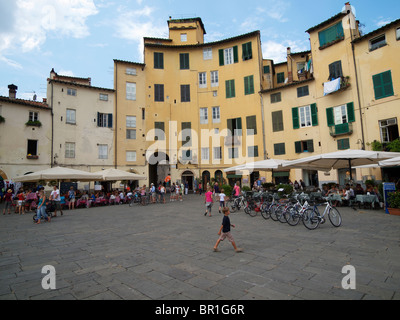 Die Piazza Amfiteatro in Lucca, Toskana, Italien wurde auf dem Fundament eines römischen Amphitheaters, daher die ovale Form gebaut. Stockfoto