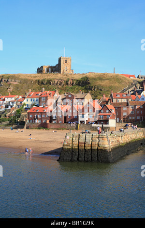 Str. Marys Kirche am East Cliff über Fischerhütten und Tate Hill Pier, niedrigere Hafen von Whitby, North Yorkshire, England, UK. Stockfoto