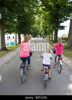 Familie Reiten vermietet Fahrräder auf die historische Stadt Wand in Lucca, Toskana, Italien Stockfoto