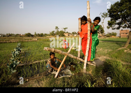 Mutter und Tochter Pumpen von Wasser mit einer Pumpe aktiviert zu Fuß auf einem abgelegenen Dorf in der Nähe von Lumbini, Nepal. Stockfoto