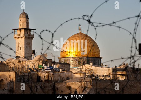 Jerusalems Kuppel des Rock und Moschee Minaretts durch Stacheldraht mit israelischen Fahnen im Vordergrund zu sehen. Stockfoto