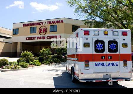 Ein Krankenwagen zieht in ein modernes Krankenhaus-Notaufnahme-Eingang. Stockfoto