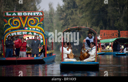 Mariachi Musiker spielen mexikanische Lieder für Touristen in einem Boot durch die Wasserkanäle von Xochimilco auf der Südseite von Mexiko C Stockfoto