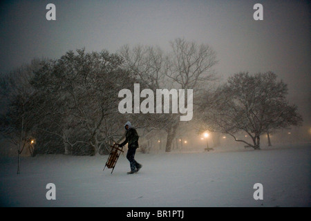 Ein einsamer Sledder wird durch eine Sprengung Schneesturm auf dem Gelände der US-Hauptstadt gesehen. Stockfoto