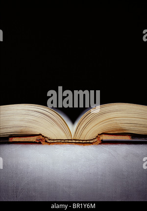 Buch offen auf einer Tischfläche mit schwarzem Hintergrund zu legen. Stockfoto