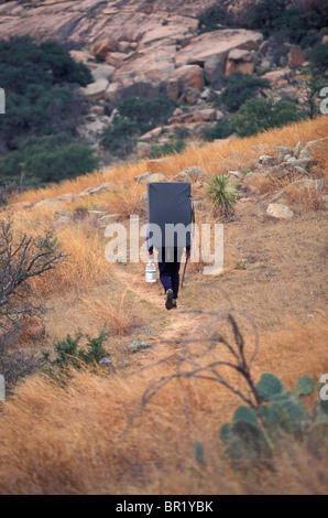 Ein Kletterer Wandern entlang eines Pfads mit seinem Crash-Pad in der Nähe von Austin, Texas. Stockfoto