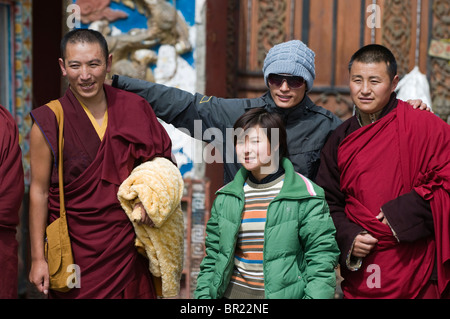 Chinesische Touristen haben Foto mit tibetisch-buddhistischen Mönchen, Tagong Kloster, Provinz Sichuan, China Stockfoto