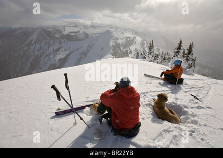 Mann, Frau und Hund unter Mittagspause während Skitouren, Britisch-Kolumbien, Kanada Stockfoto