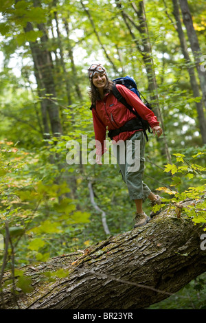 Frau auf umgestürzten Baum zu balancieren. Stockfoto