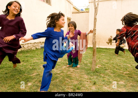 Kinder lachen und spielen im Hof ihres Hauses in Kabul. Stockfoto