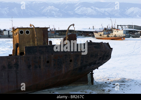 Ein verlassenes Schiff verließ den Hafen auf dem gefrorenen See Baikal während des Winters auf Olchon, Sibirien, Russland. Stockfoto