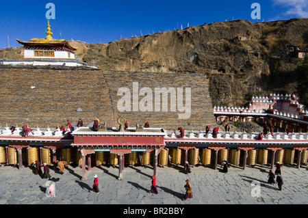 Tibetisch-buddhistische Pilger abbiegen golden Gebetsmühlen Huiyuan Tempel, Bamei, Provinz Sichuan, China Stockfoto
