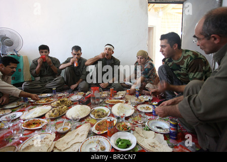 Eine Gruppe kurdischer Kämpfer der Volksverteidigungskräfte HPG, dem militärischen Flügel der Kurdischen Arbeiterpartei PKK, isst traditionelle kurdische Lebensmittel in einem sicheren Haus in einer ländlichen Siedlung in den Kandil-Bergen, einem Berggebiet nahe der irakischen Grenze zum Iran Stockfoto