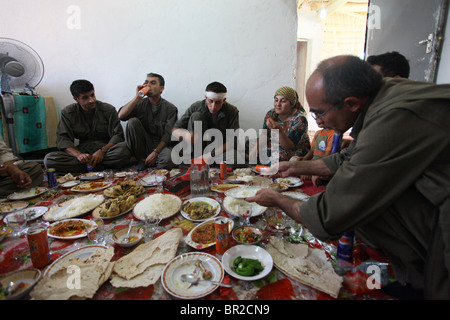 Eine Gruppe kurdischer Kämpfer der Volksverteidigungskräfte HPG, dem militärischen Flügel der Kurdischen Arbeiterpartei PKK, isst traditionelle kurdische Lebensmittel in einem sicheren Haus in einer ländlichen Siedlung in den Kandil-Bergen, einem Berggebiet nahe der irakischen Grenze zum Iran Stockfoto