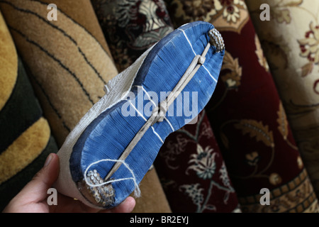 Mann hält eine traditionelle "Sokoban" Hand Watte Schuh in Kurdistan gemacht in einem Souvenirshop in der Stadt Erbil Arbil oder Irbil auch die Hauptstadt der Region Kurdistan im Nordirak geschrieben. Stockfoto