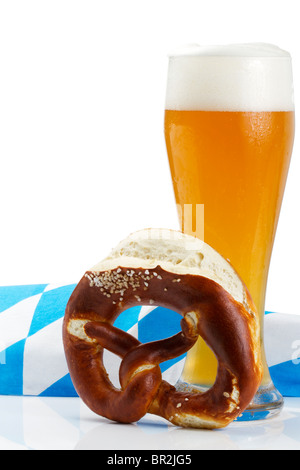 Weizenbier mit bayerischen Handtuch und Brezel auf weißem Hintergrund Stockfoto