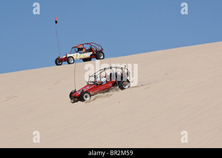 Ein Teenager, der einen Dünen-Buggy über Sanddünen fährt, ist in Michigan, MI, USA, in flachem Winkel von unter dem Horizont des US-Lifestyle-Lebens hochauflösend Stockfoto