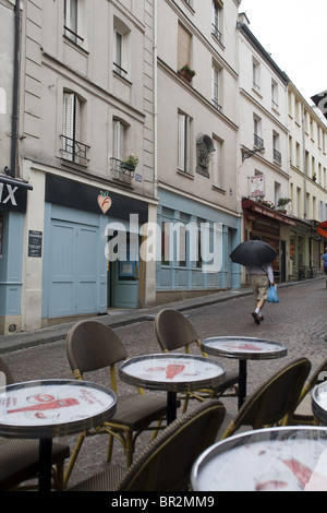 Ein Mann mit einem Regenschirm geht bis Rue Moufftard, einen berühmten Lebensmittelmarkt im Regen mit seinen Einkaufsmöglichkeiten. Paris, Frankreich Stockfoto