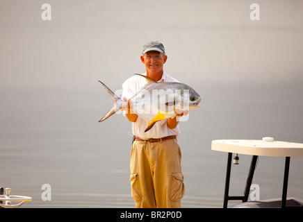 Porträt von Fischer hält einen gefangenen Fisch Stockfoto