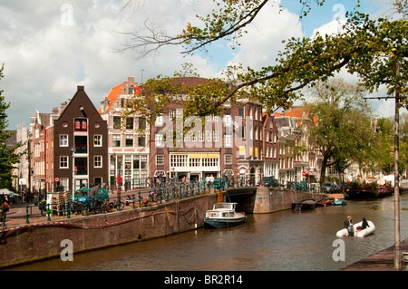 Amsterdam-Kanal mit einem weißen Boot gebucht Stockfoto