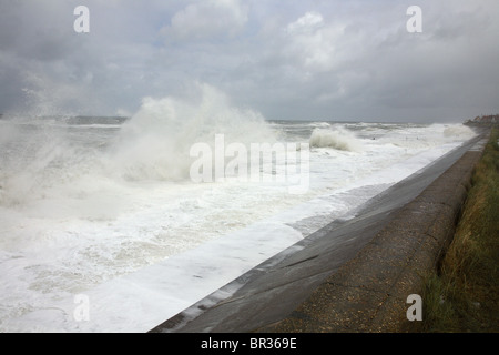 Stürmische See Wellen gegen ein Deich an der Küste von Norfolk. Stockfoto