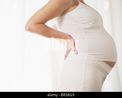 Ansicht des italienischen 7 Monate schwangere Frau massieren ihren Rücken zugeschnitten. Horizontale Form, Seitenansicht, Textfreiraum Stockfoto