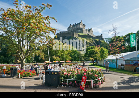 Edinburgh Castle mit Besucher genießen das gute Wetter aus Westen Princes Street Gardens im schottischen Edinburgh angesehen. Stockfoto