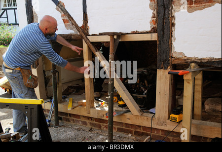 Renovierung einer alten Holz gerahmt Gebäude Arbeiter Einführung neuen Eiche auf einer Außenwand Stockfoto